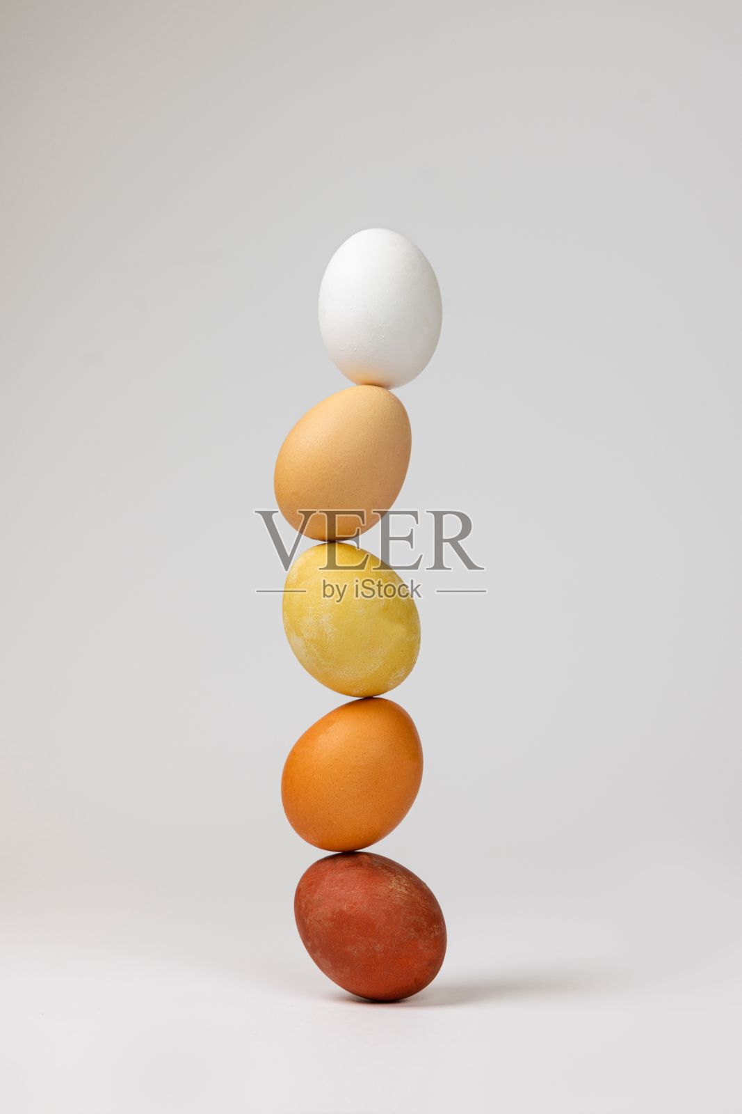 竖直拍摄的彩蛋堆叠在另一个白色背景上照片摄影图片