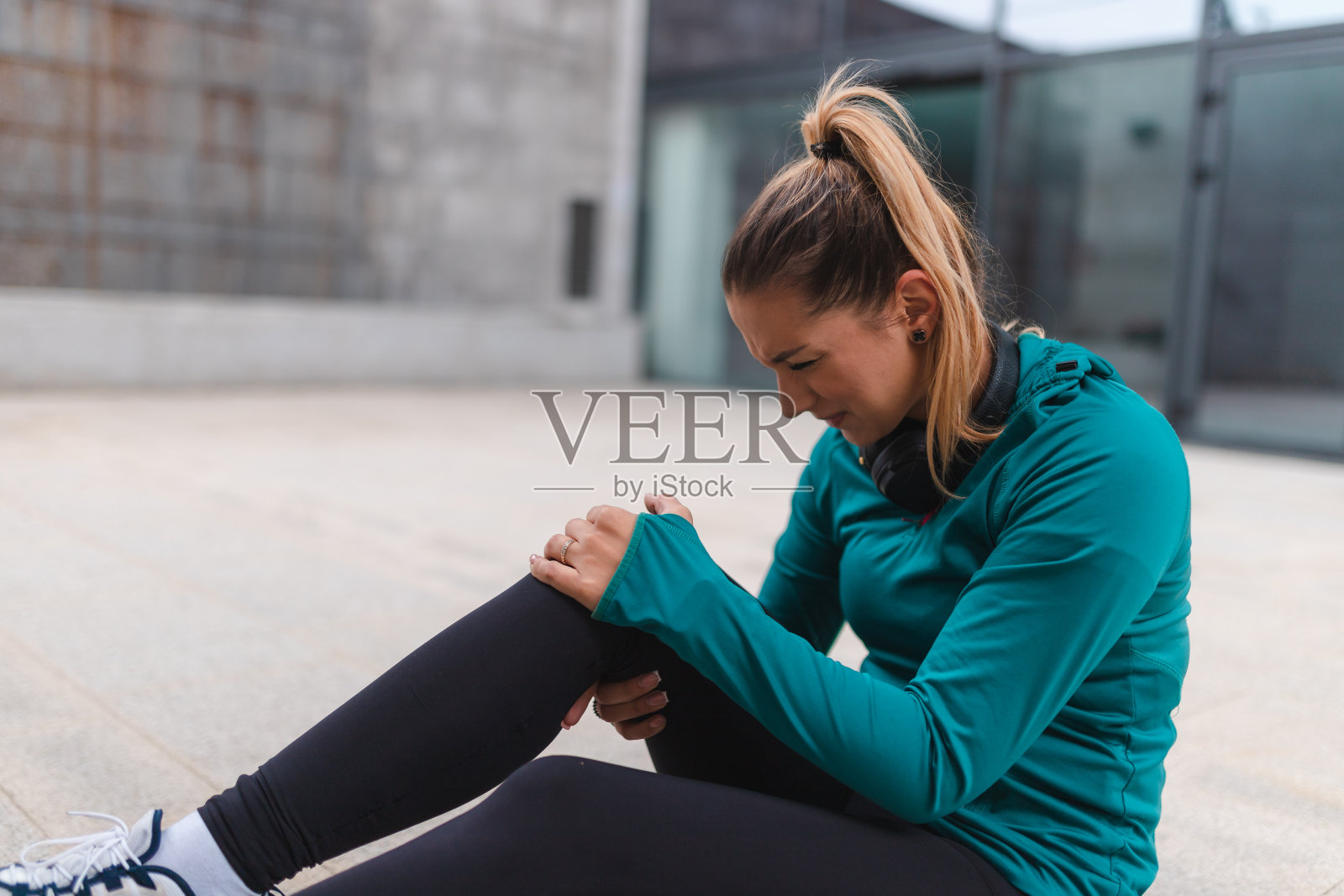年轻的女运动员在户外锻炼时膝盖受伤照片摄影图片