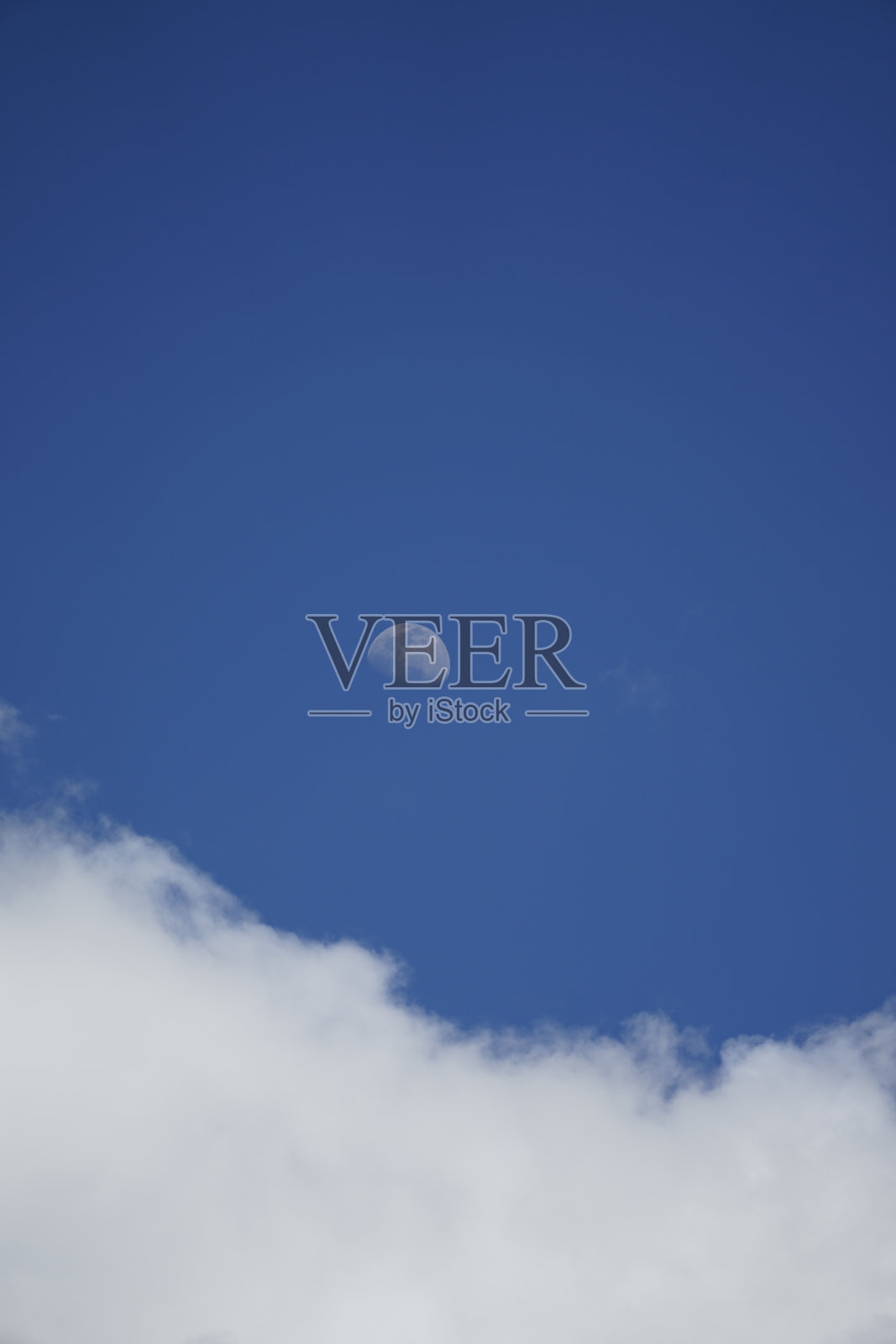 湛蓝的天空上,月亮在浮肿的积云上,景色宁静照片摄影图片