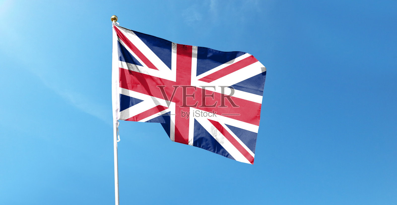 多云天空上的英国国旗。在天空中挥舞照片摄影图片