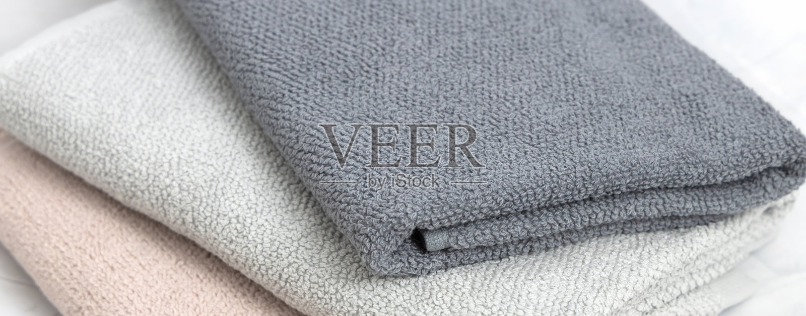 折叠干净的毛巾在白色大理石背景。照片摄影图片