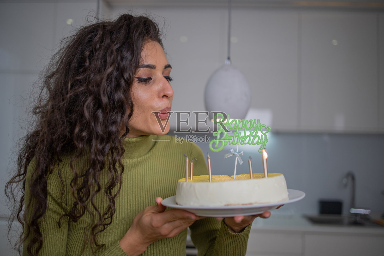 快乐的女士拿着生日蛋糕和蜡烛在家里照片摄影图片