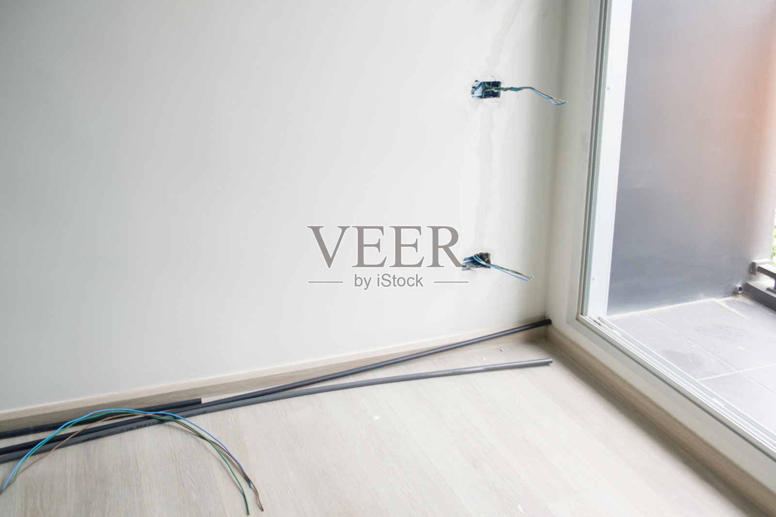 石膏下的电线,混凝土插座的隐藏安装电缆。住宅和公寓概念的改造、维修和发展照片摄影图片