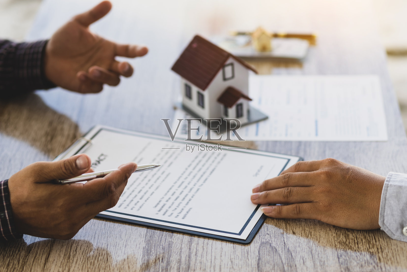 房地产中介正在讨论签订合同、法律协议、土地购买、抵押贷款和房屋租赁的条款。照片摄影图片