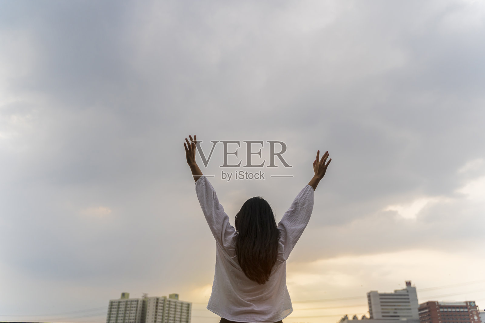 背面的快乐的年轻亚洲妇女举起手。自由的概念。照片摄影图片