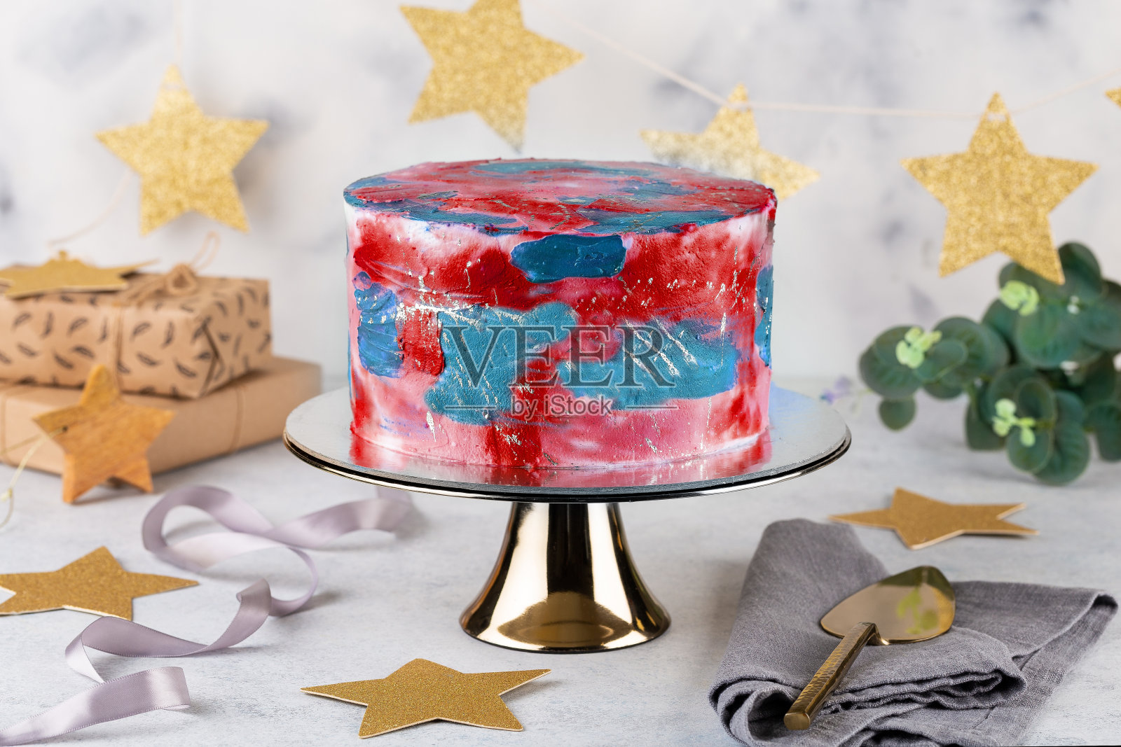 蓝色背景上的彩色蛋糕。带有彩色奶油奶酪糖霜的生日蛋糕照片摄影图片