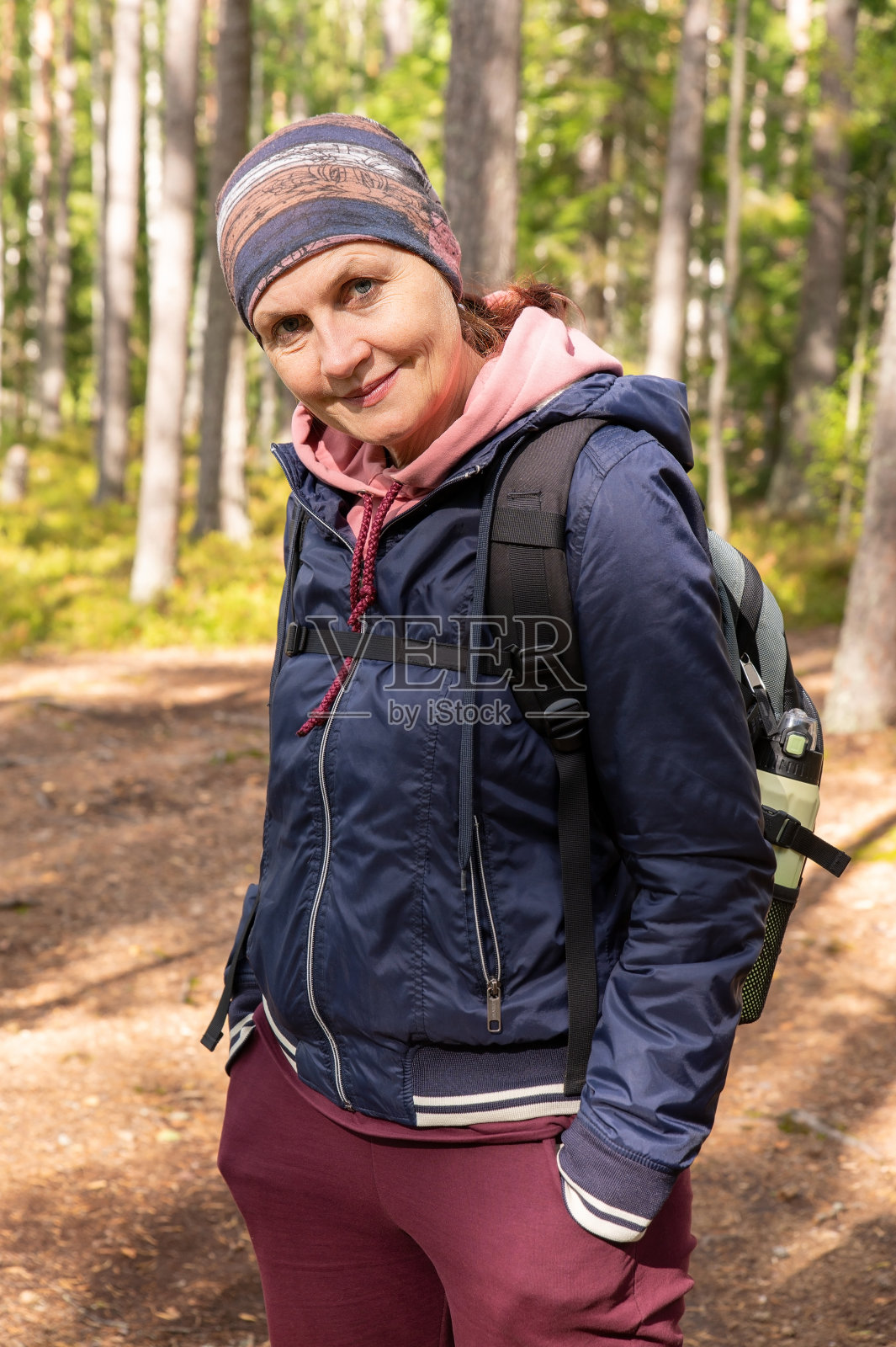 一个成年迷人的女人,穿着运动服和夹克,肩上背着一个小背包照片摄影图片