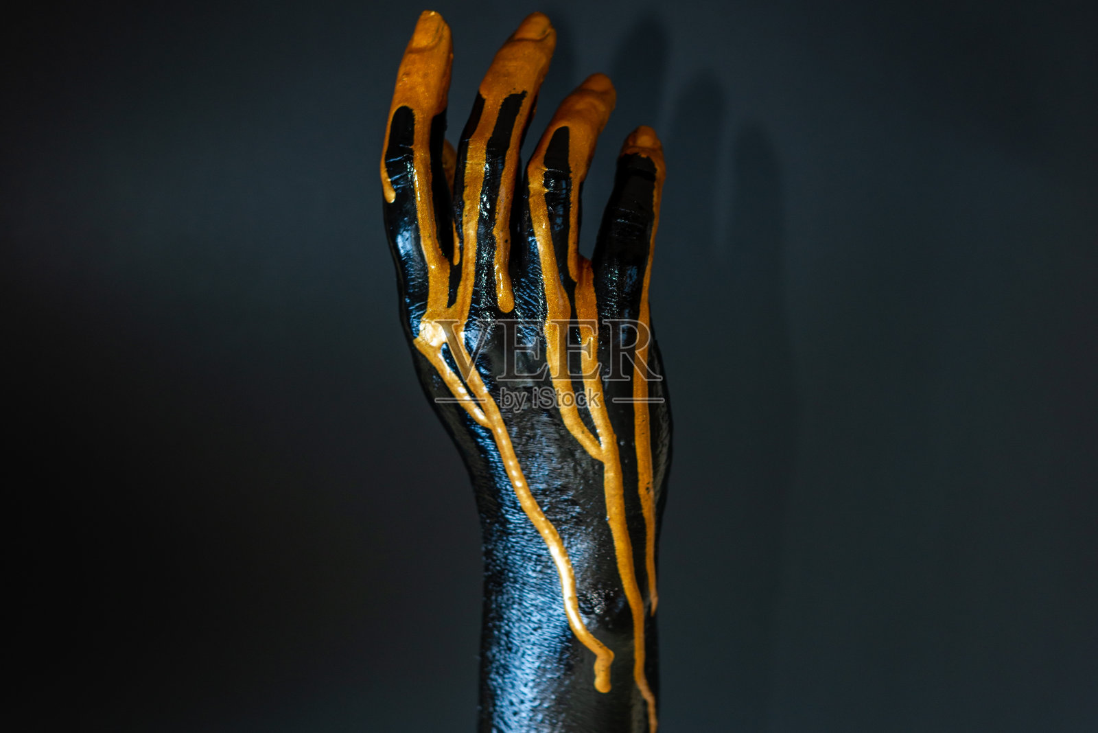 优雅的女性手与黑色和金色颜料在她的皮肤与黑色背景照片摄影图片