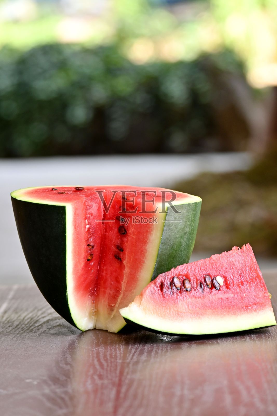 木桌上竖着一片红熟西瓜照片摄影图片