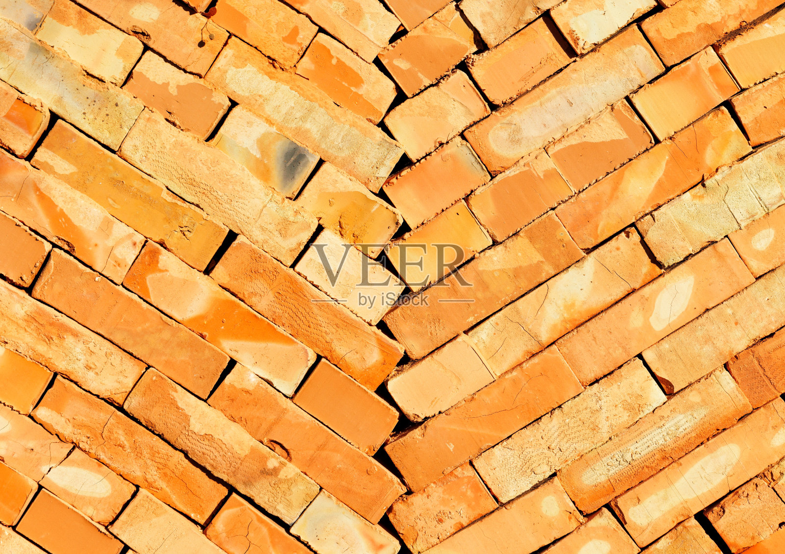 橙色的建筑砖向中心斜堆成两列。照片摄影图片