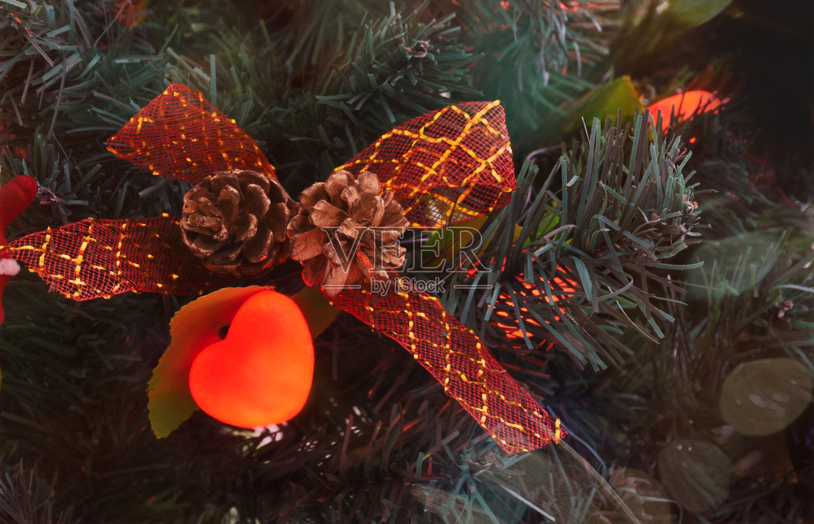 心形圣诞装饰品系带花边,松果在圣诞树上照片摄影图片