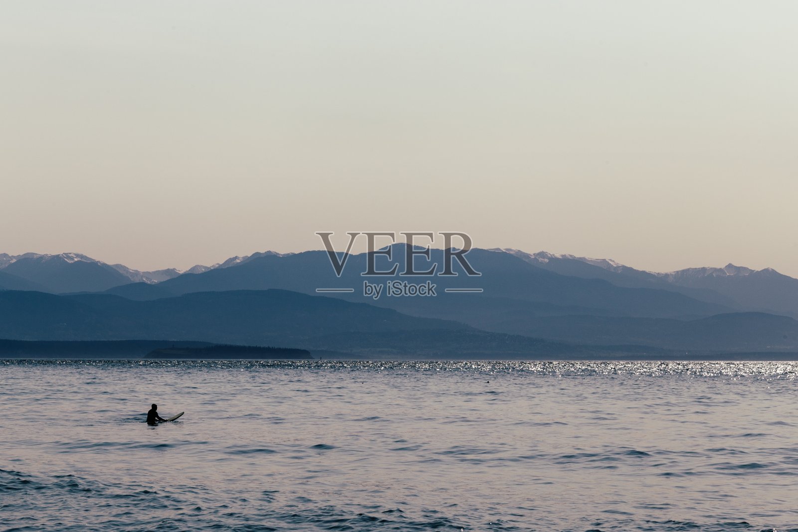 一个冲浪者把他的冲浪板放在水里照片摄影图片