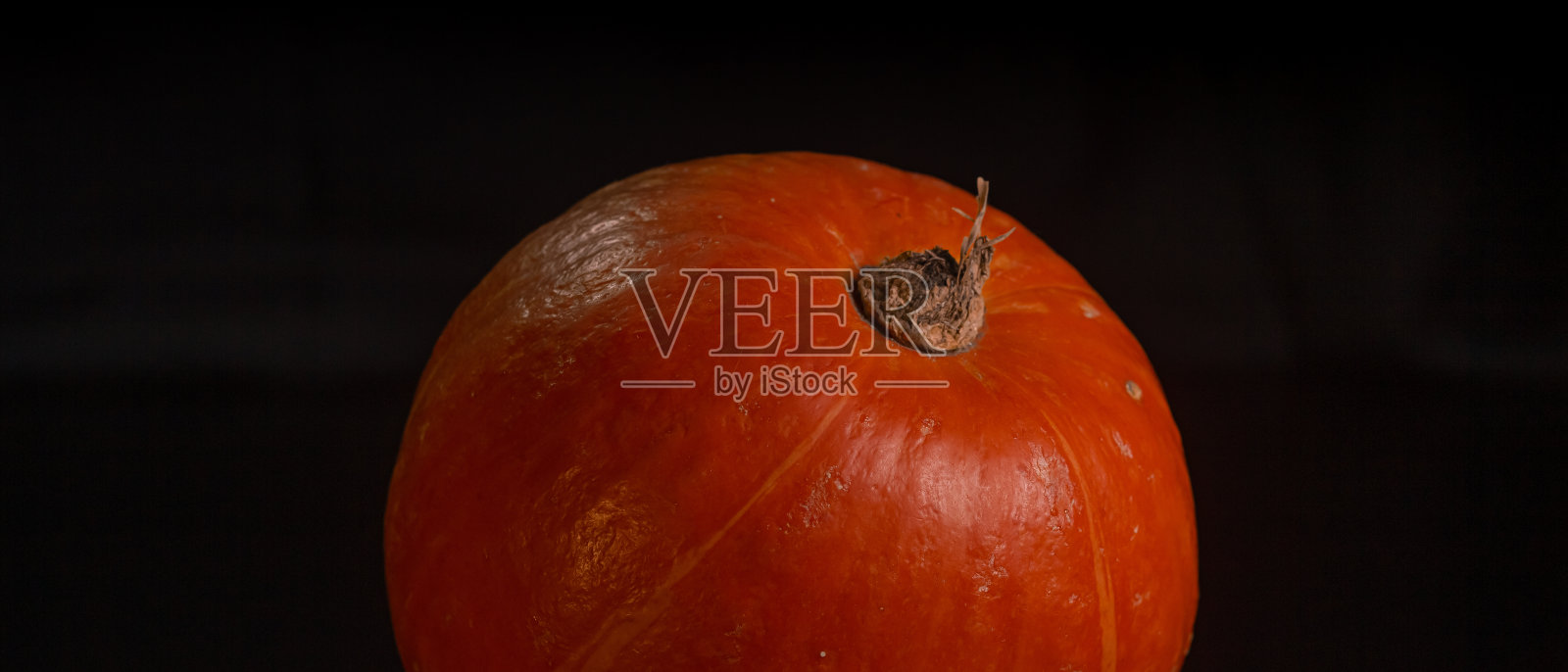 橘黄色的南瓜在黑色的背景上万圣节的概念和秋天收获的南瓜特写复制空间从上面照片摄影图片