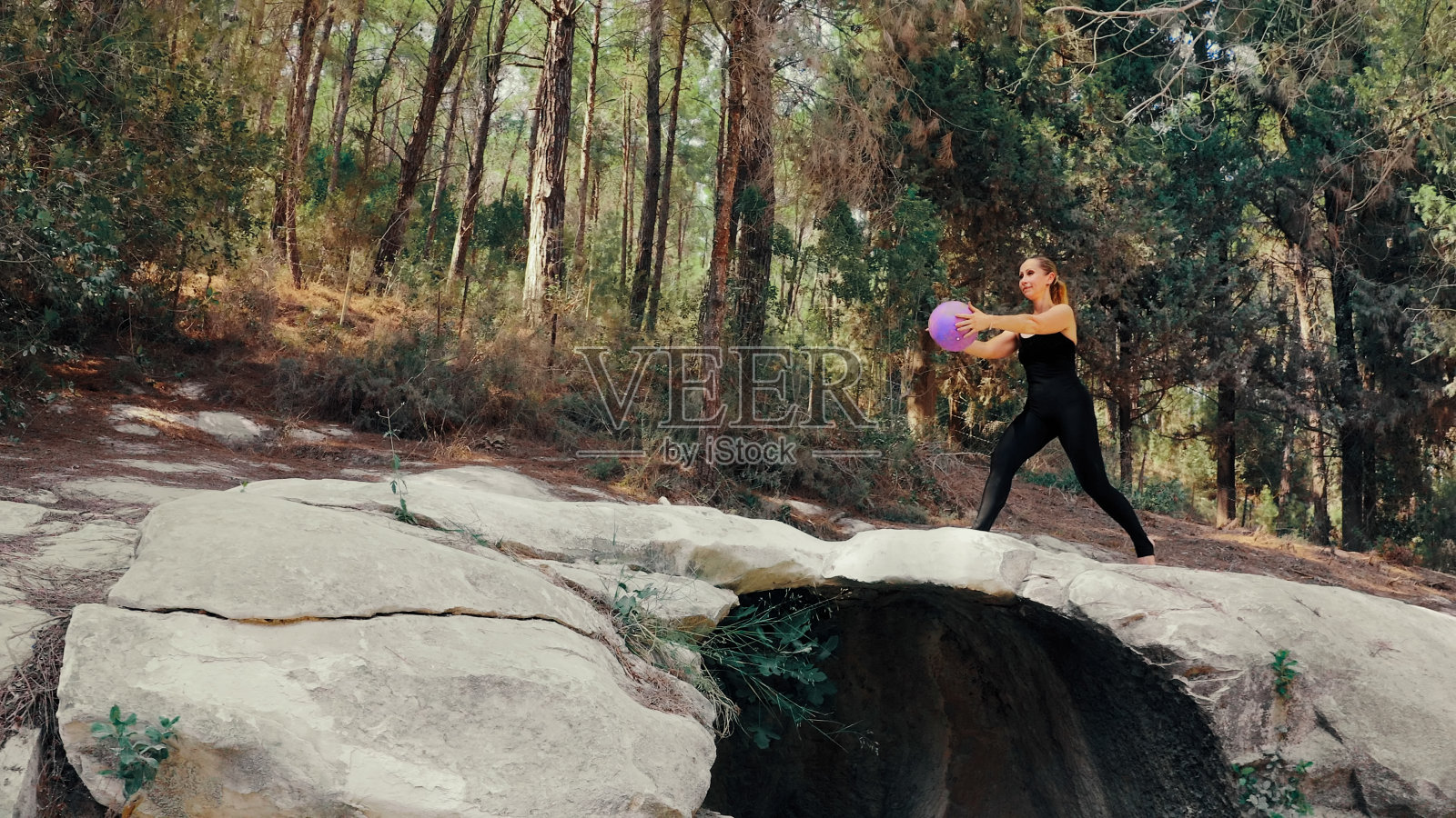 一名身穿运动服的女子在公园里用健身球锻炼身体照片摄影图片