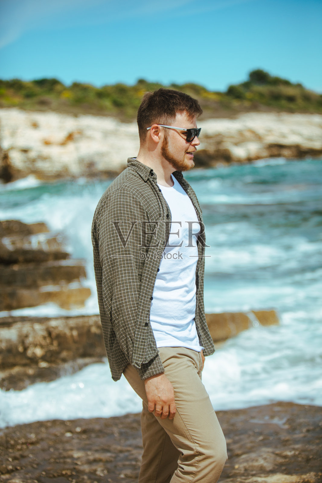 年轻人戴着墨镜,胡子肖像在海边照片摄影图片