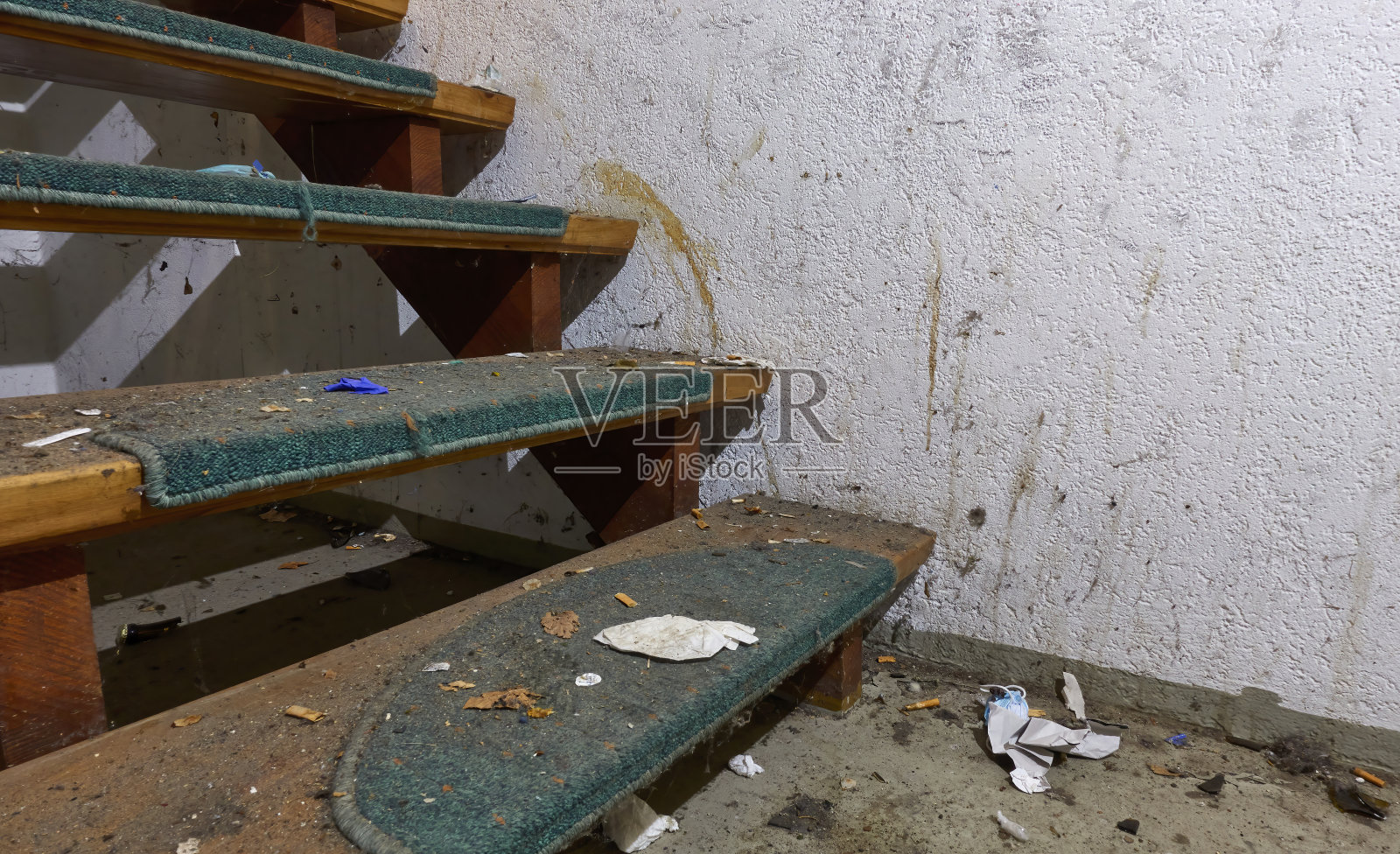 与许多垃圾接近一步。大楼里非常脏的楼梯。凌乱不做扫地(Kehrwoche)。照片摄影图片