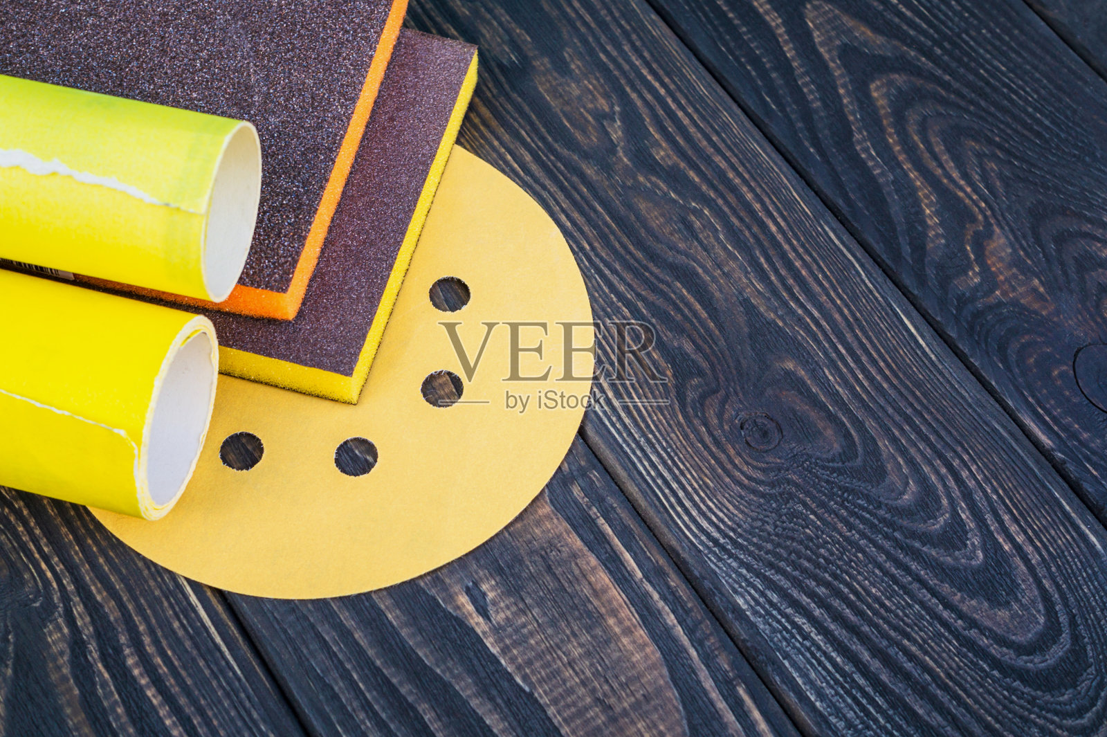 一套不同颜色的磨具和砂纸在黑色古董木背景照片摄影图片