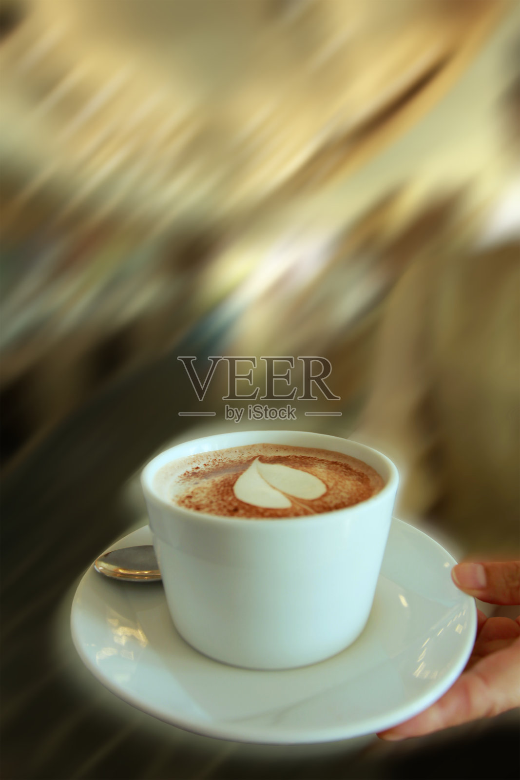 咖啡——装饰着叶子形状的咖啡,在一个白色的碟子里,随时准备端上来照片摄影图片