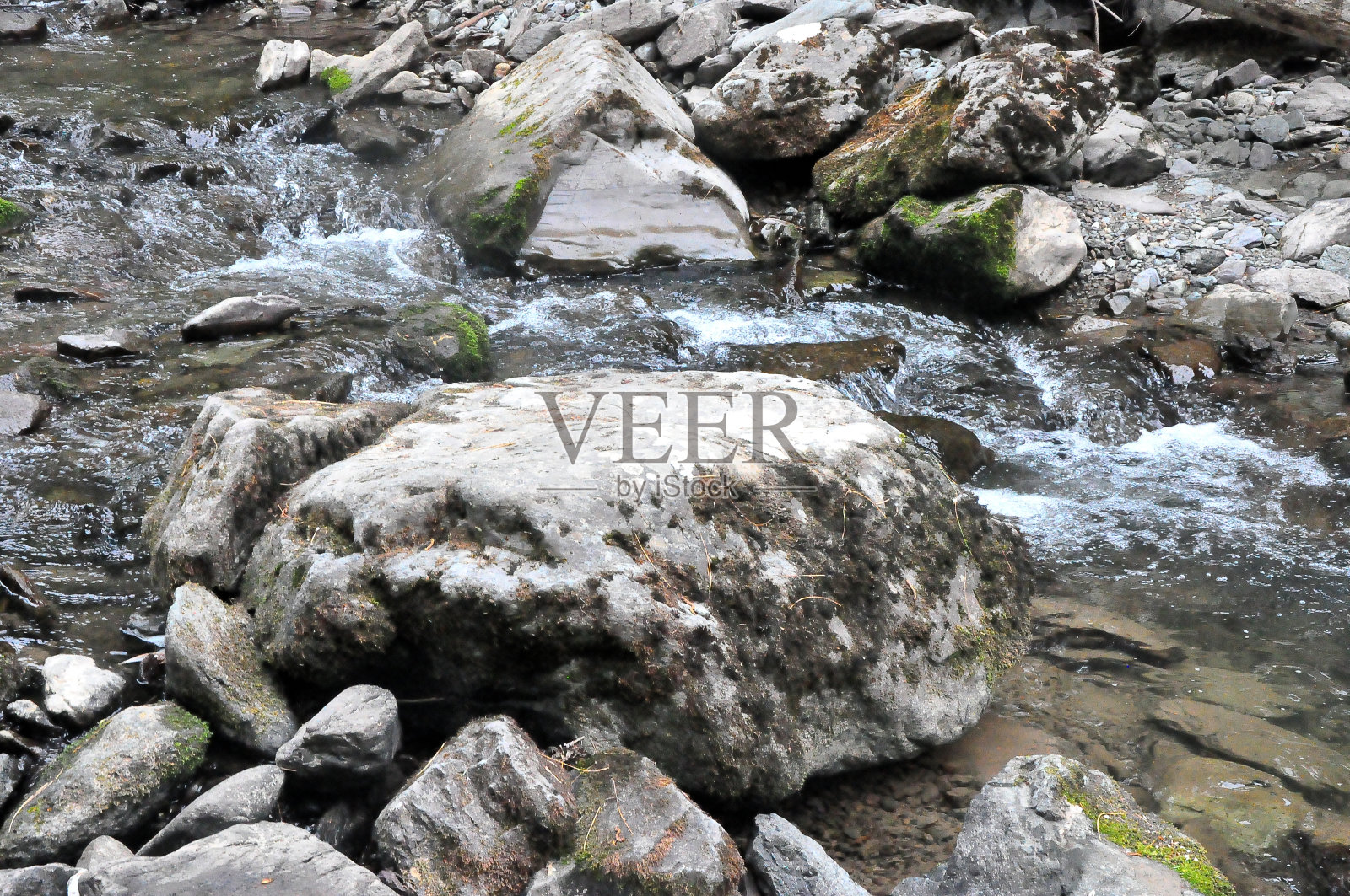 大石块在小山河河床的近景。照片摄影图片