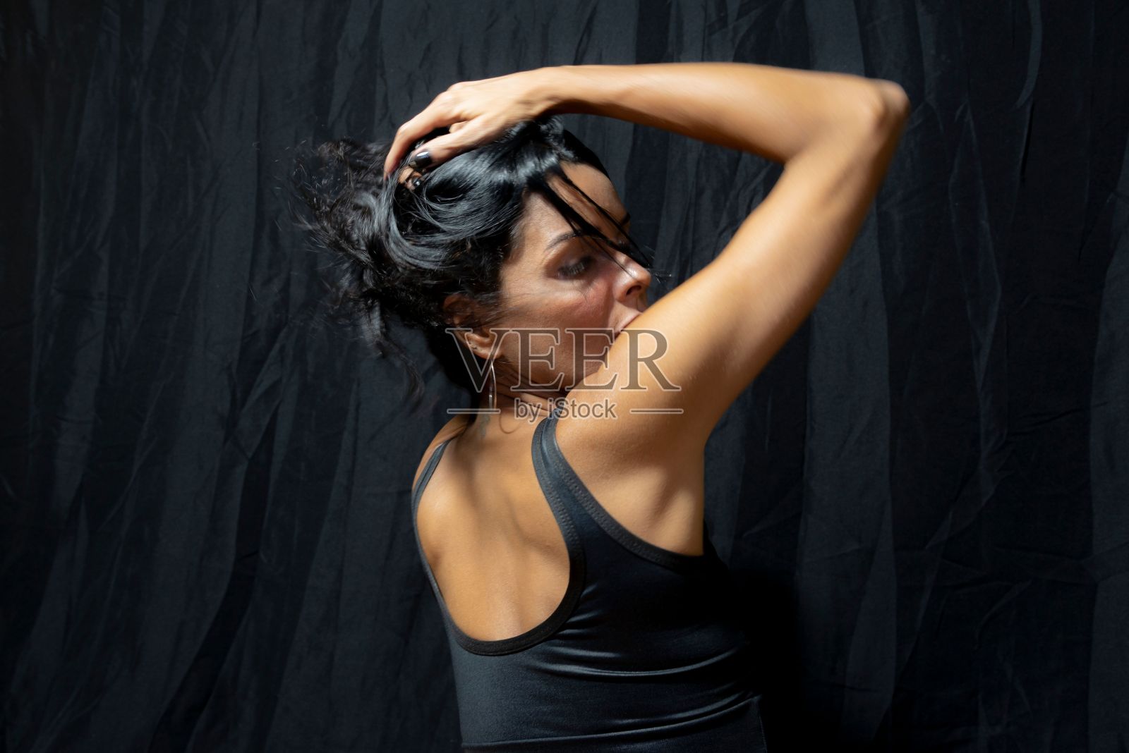 一名白人女性在黑色背景下展示她的后背照片摄影图片