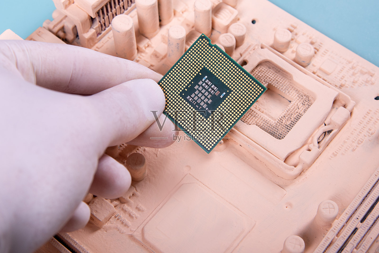 主板和鲁阿卡拿着一个微处理器在蓝色背景上油漆照片摄影图片