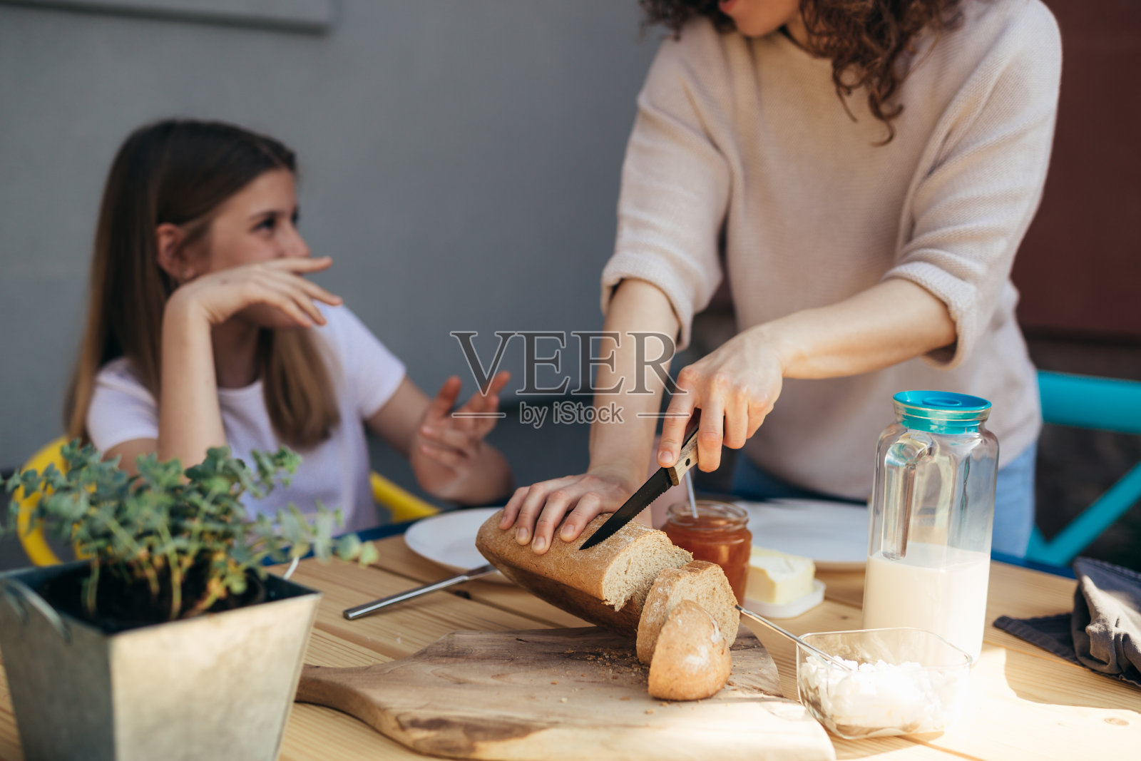 母亲和女儿在后院吃早餐照片摄影图片