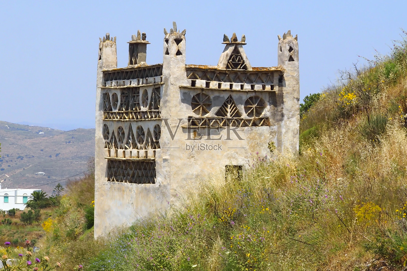 蒂诺斯岛位于爱琴海中心的基克拉迪群岛,岛上有许多鸽舍,分布在各种各样的风景中。这些鸽舍是当地建筑的特色照片摄影图片