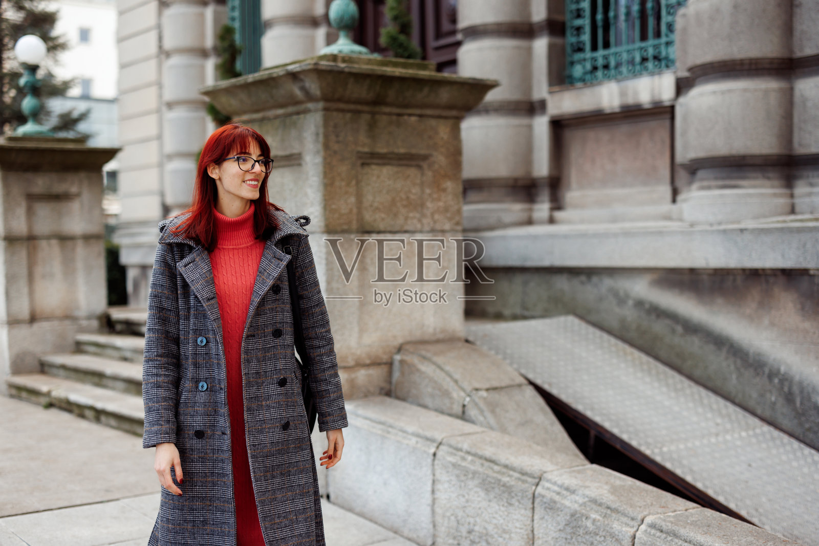 微笑的年轻女子走在城市里照片摄影图片