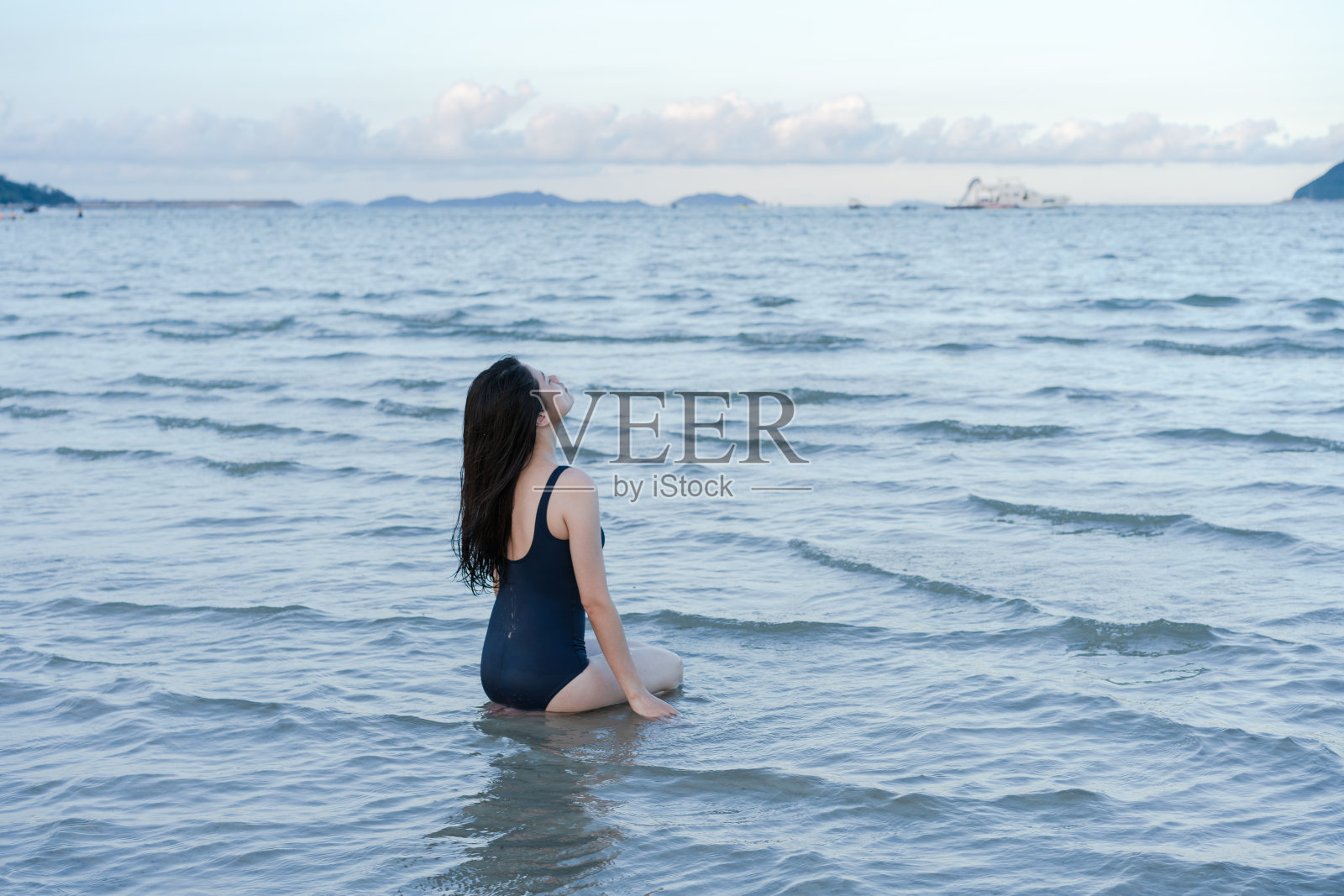 一名女子跪在浅水中照片摄影图片