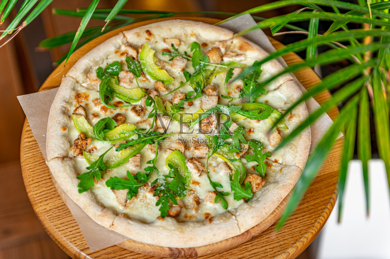 美味的披萨配烤鸡、牛油果和芝麻菜。照片摄影图片