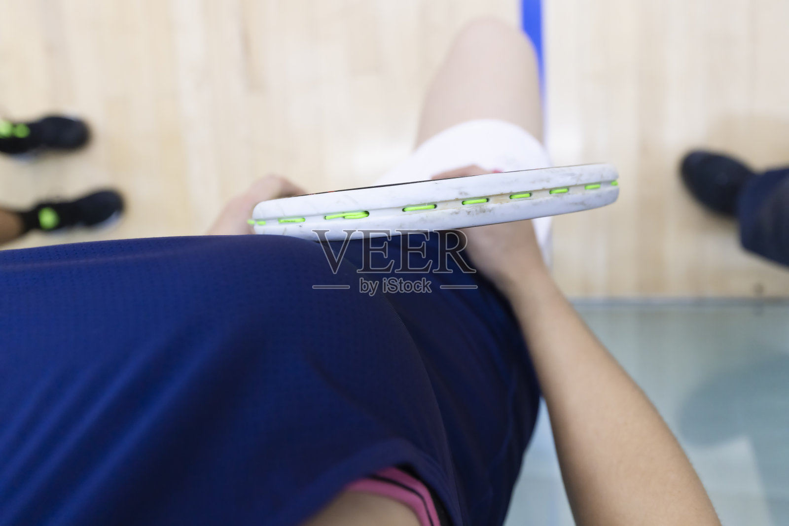 向下看的女孩,她的壁球拍和运动服。照片摄影图片