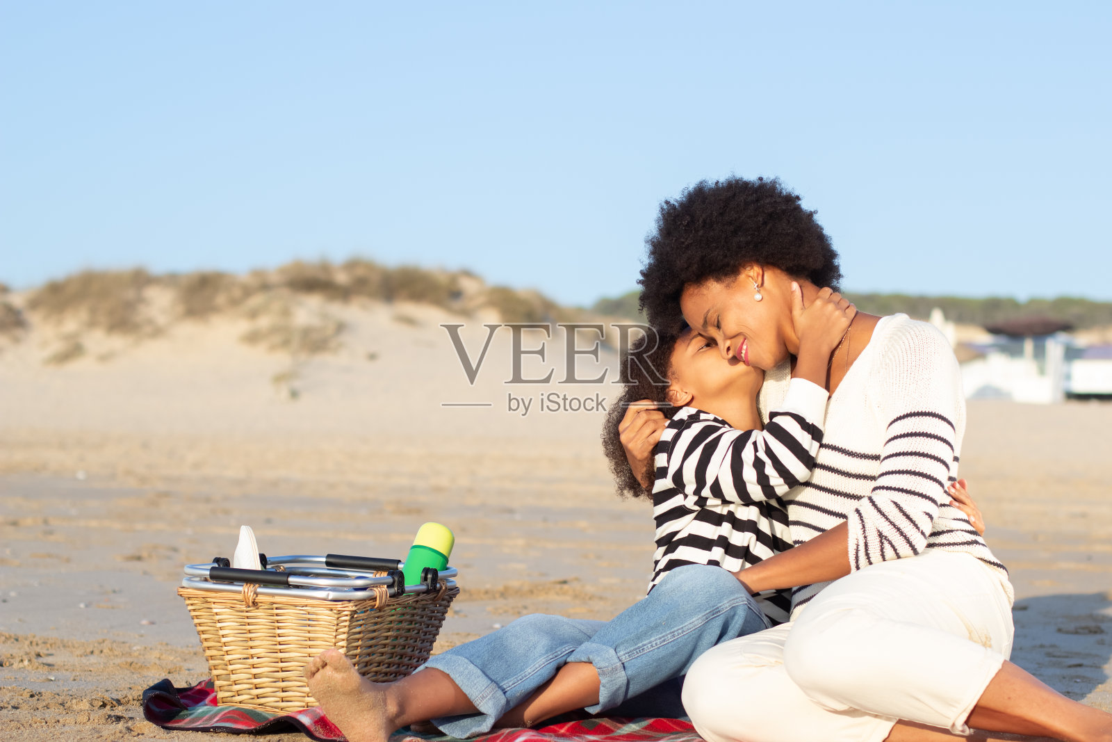快乐的非裔美国家庭在海滩野餐照片摄影图片