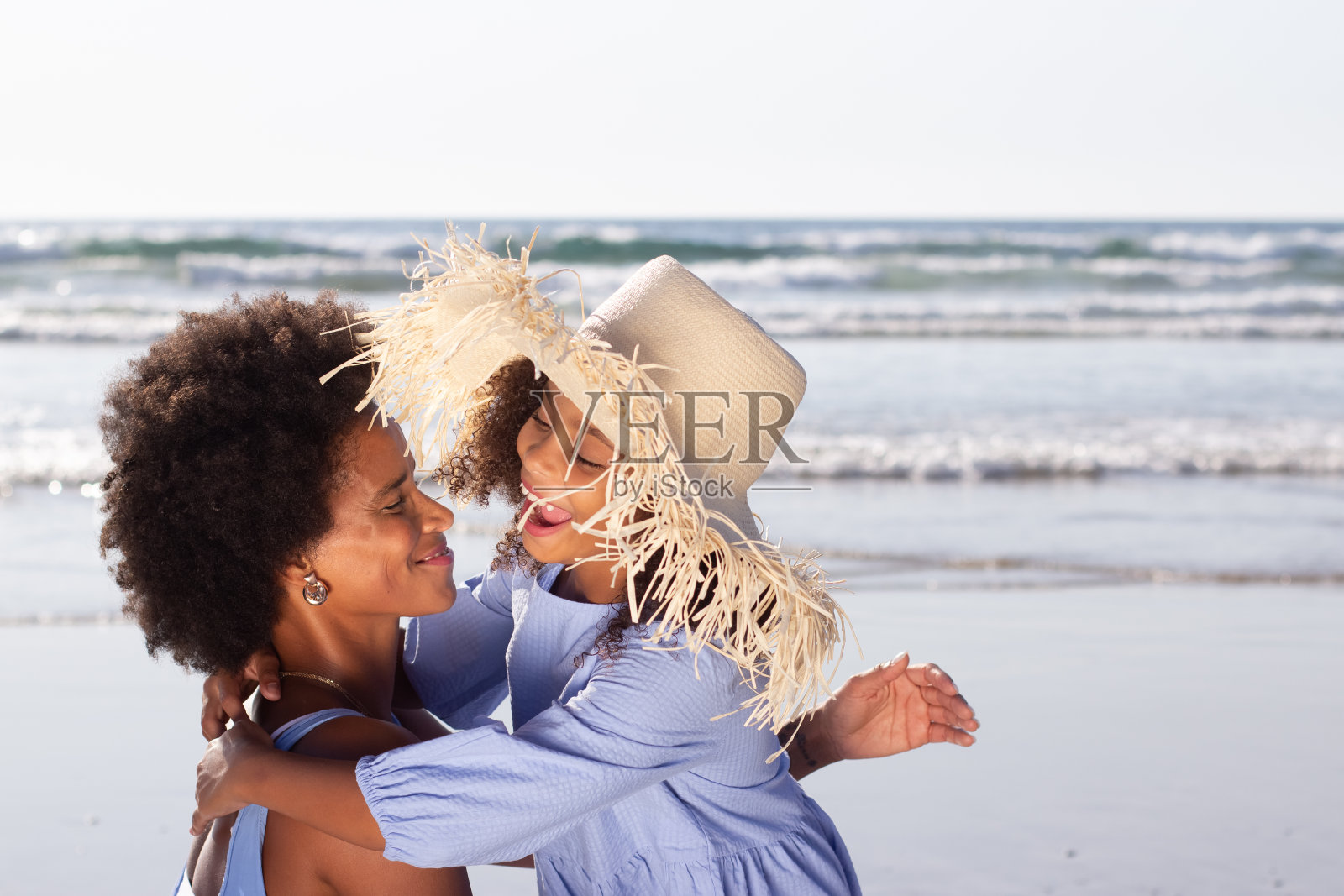 顽皮的母亲和女儿在海滩上度过时光照片摄影图片