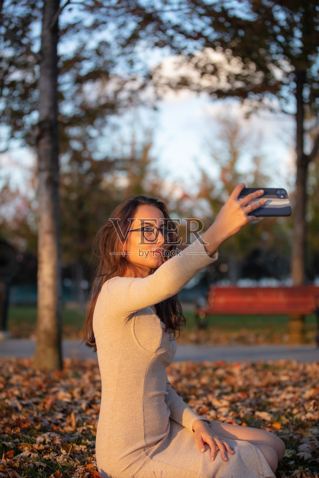 美丽的年轻女子戴着眼镜在大自然中自拍。照片摄影图片