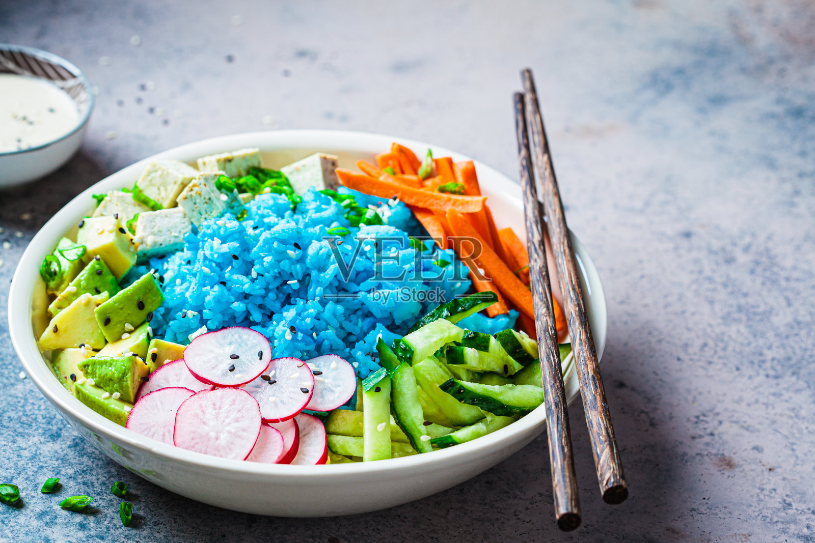 青米碗里有豆腐、牛油果、胡萝卜、黄瓜和萝卜。素食健康饮食的健康蛋白佛碗。照片摄影图片