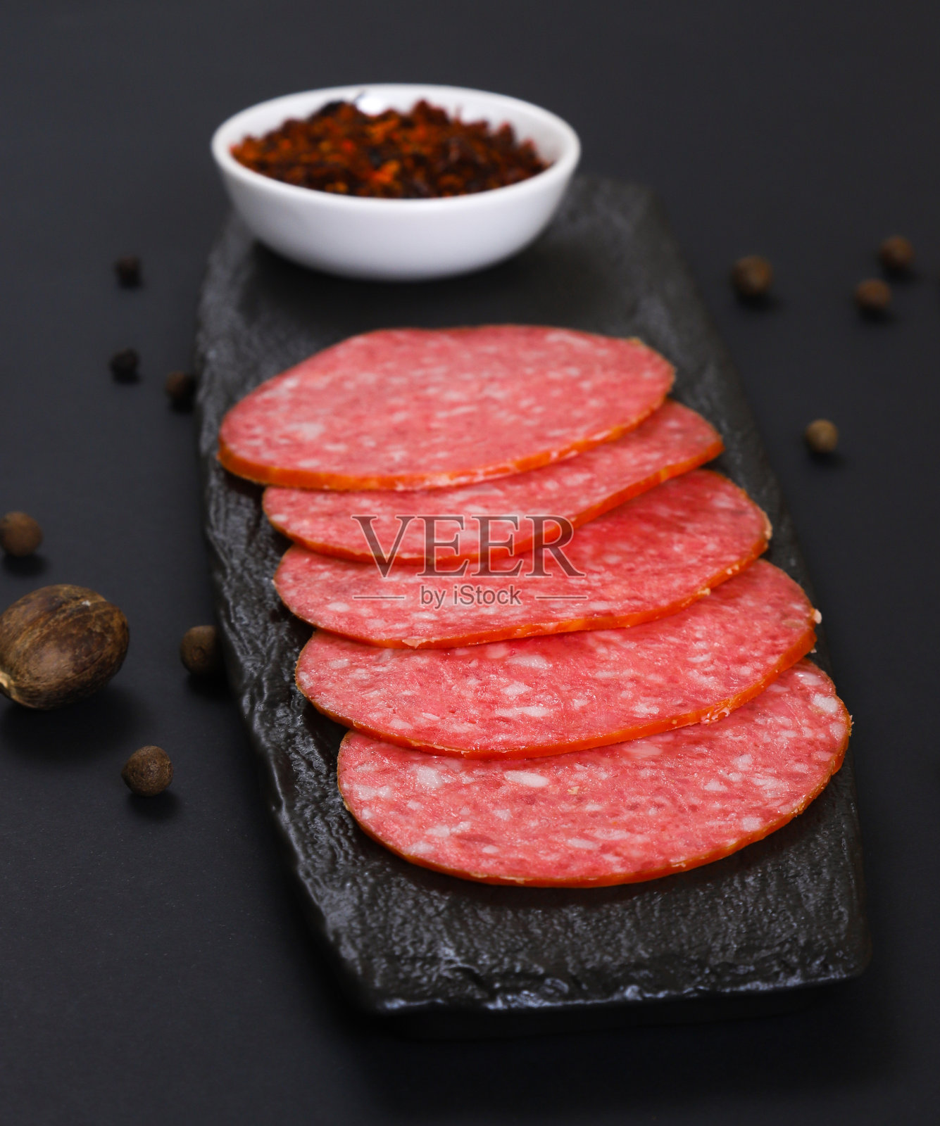 切好的香肠片放在深色的背景上。浅景深照片摄影图片