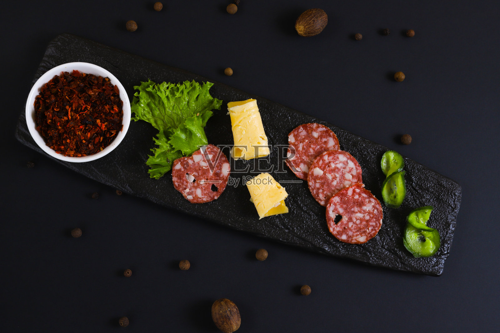 干adjika装在白色容器中,与其他材料放在黑色支架上。浅景深照片摄影图片