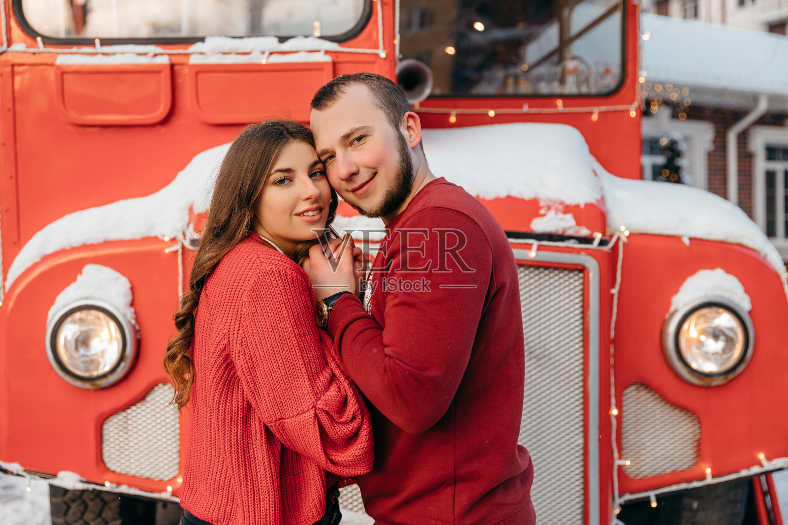 快乐的女孩抱着心爱的男朋友,对着雪城甜甜地笑着照片摄影图片