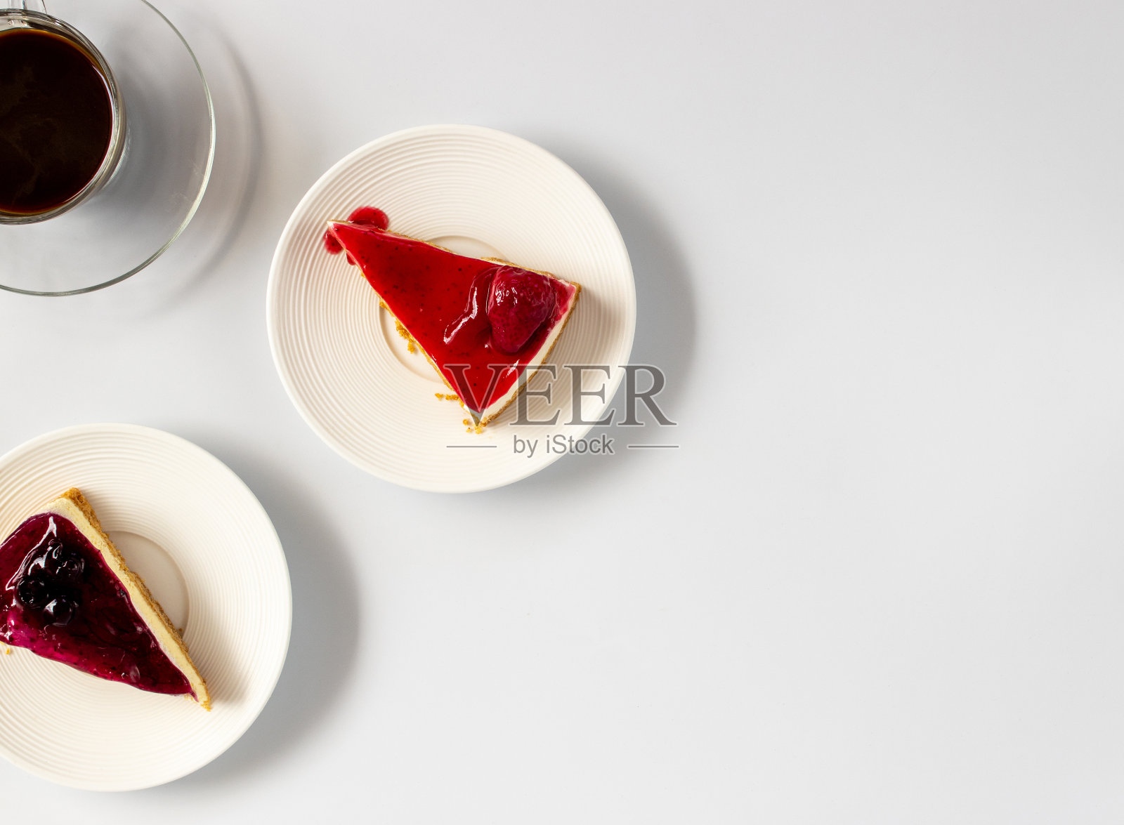 白色盘子上的草莓芝士蛋糕和蓝莓芝士蛋糕的俯视图。照片摄影图片