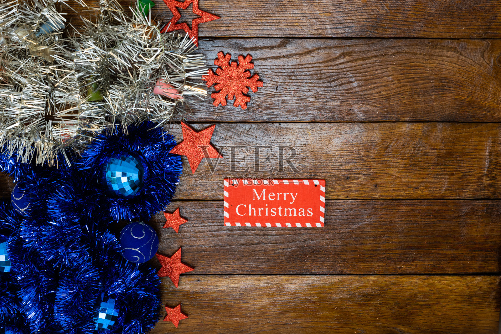 五颜六色的圣诞花环。圣诞构图在木板与圣诞花环和装饰品。照片摄影图片