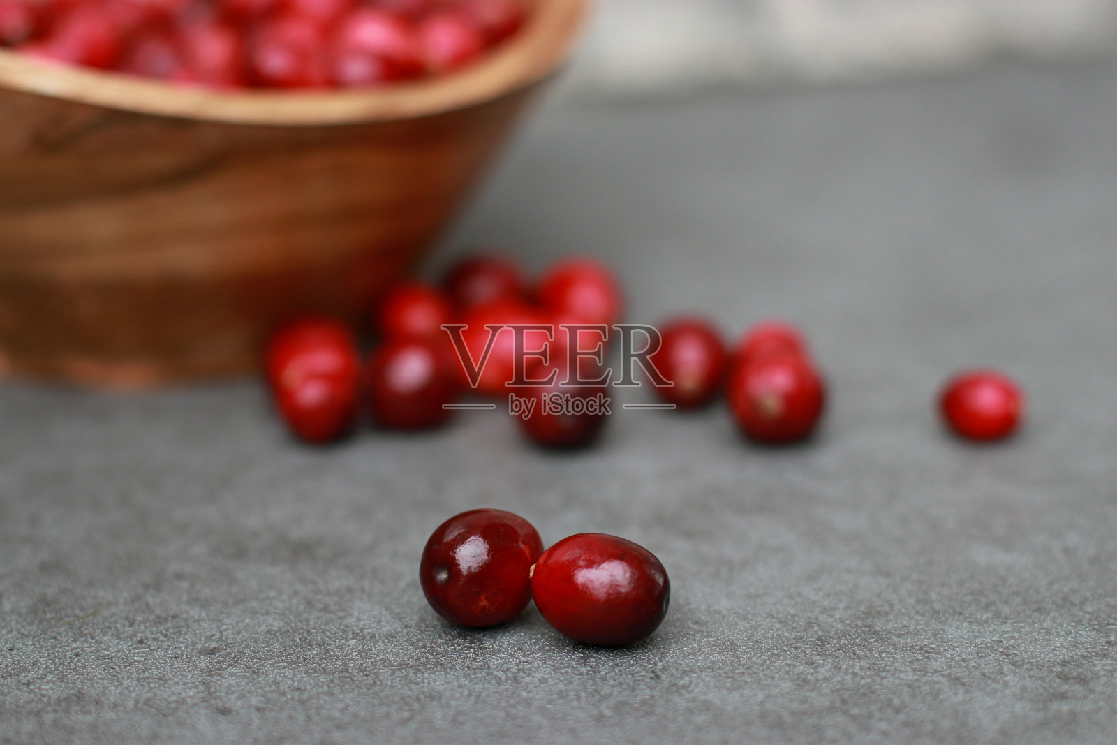 特写新鲜的蔓越莓在灰色大理石桌上,模糊的背景照片摄影图片