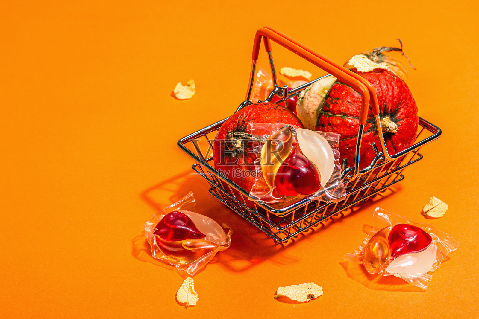 机洗概念。胶囊里有清洁剂,柔软的毛巾和秋天的装饰。洗衣豆荚照片摄影图片