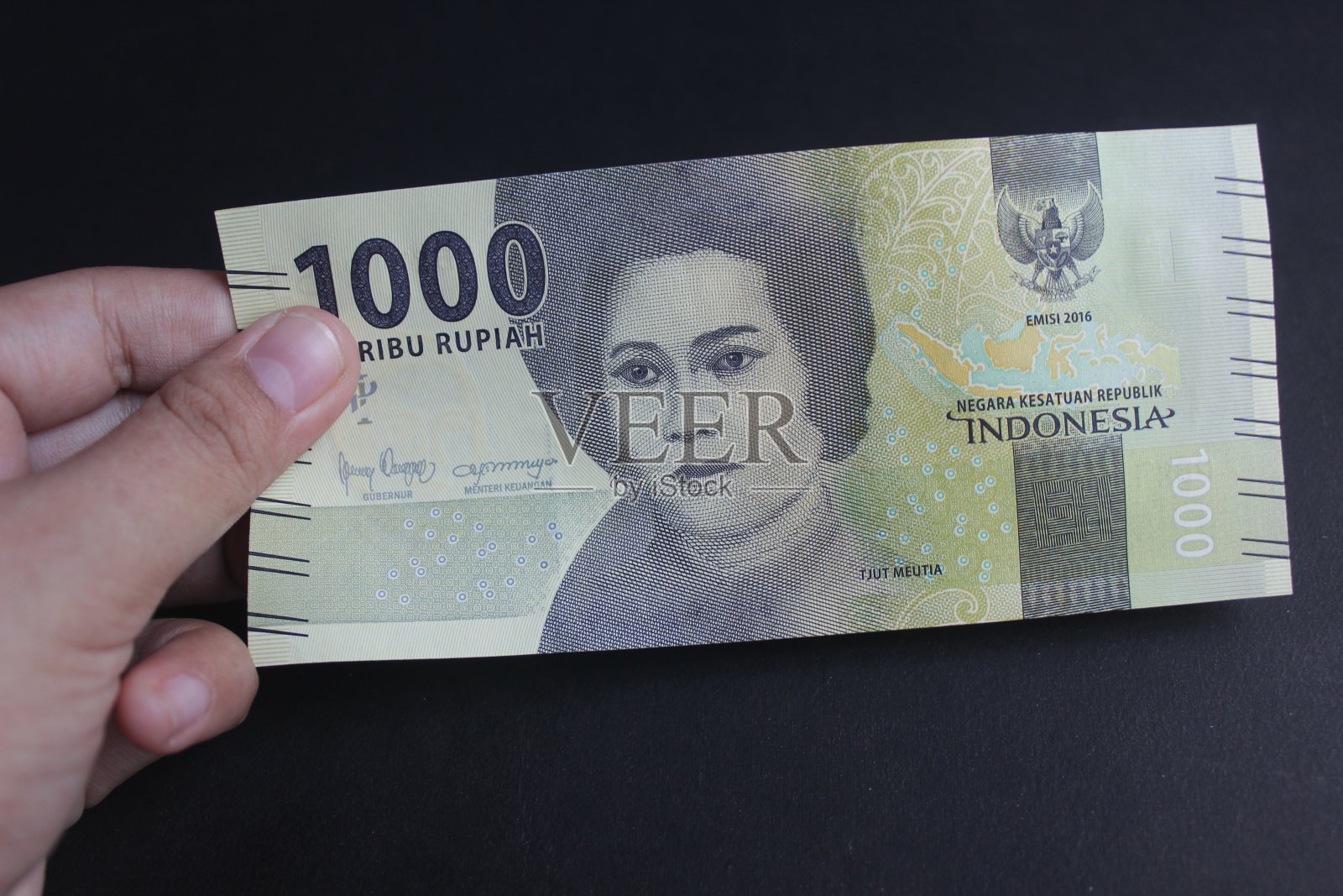 手里拿着印尼盾照片摄影图片