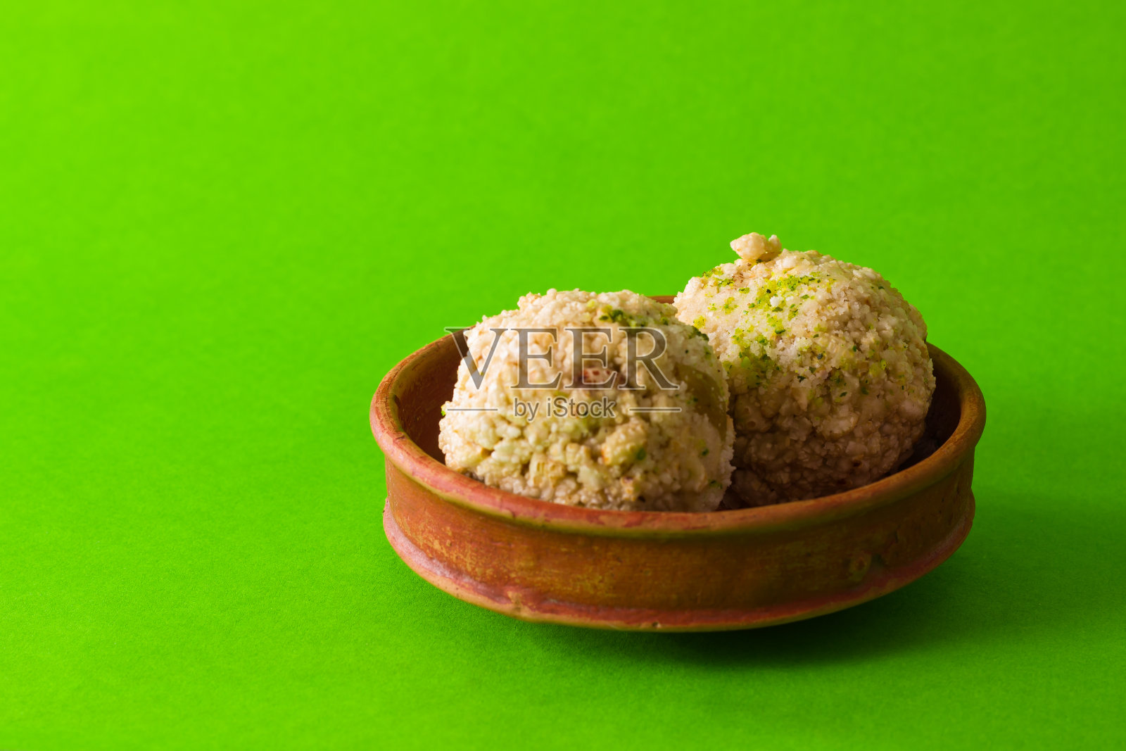 Moa是一种受欢迎的孟加拉甜点,盛在陶制盘子里。这是用蓬松的大米做成的丸子。冬季著名的甜食。照片摄影图片