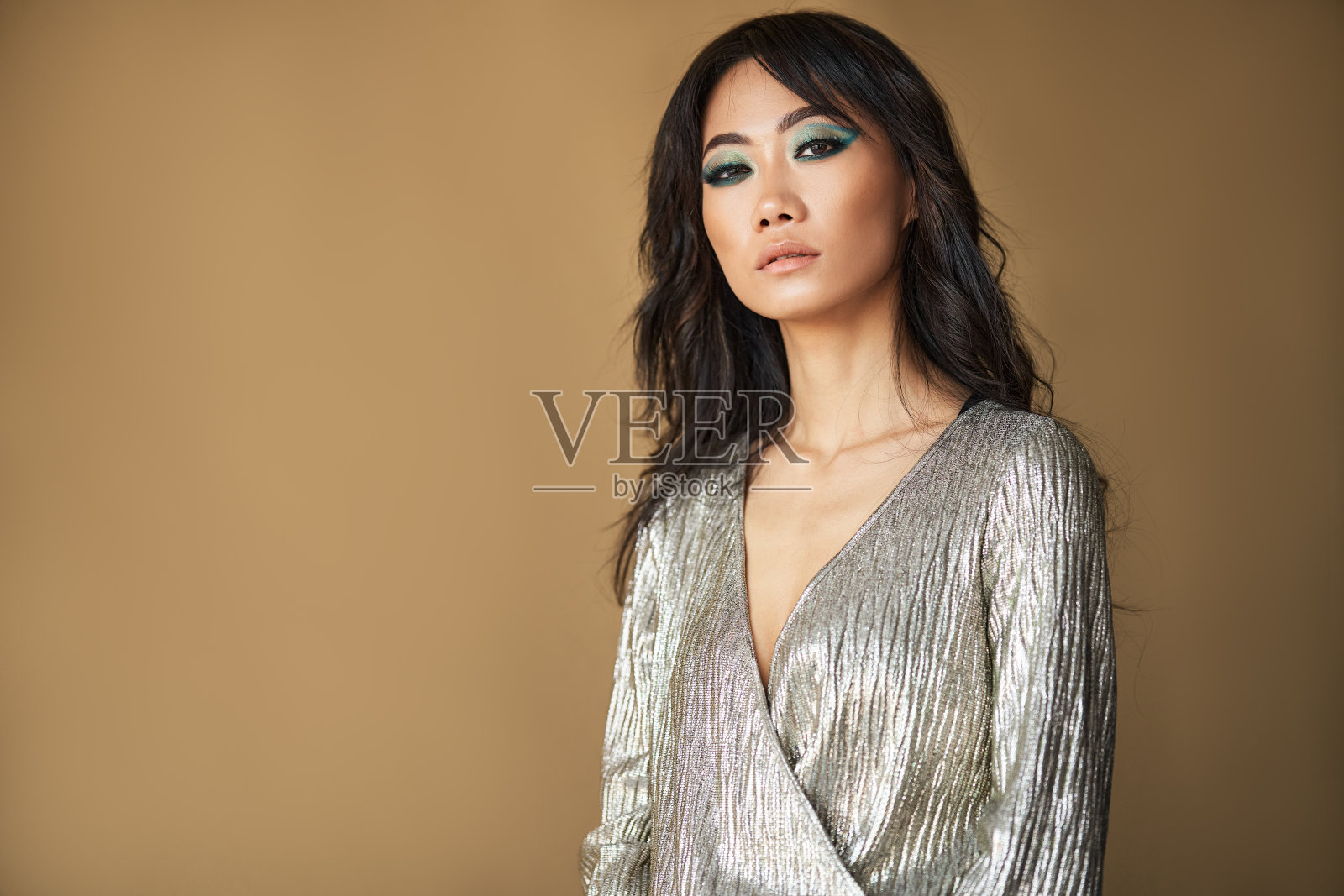 自信的漂亮女人,长发和明亮的妆容看着镜头照片摄影图片