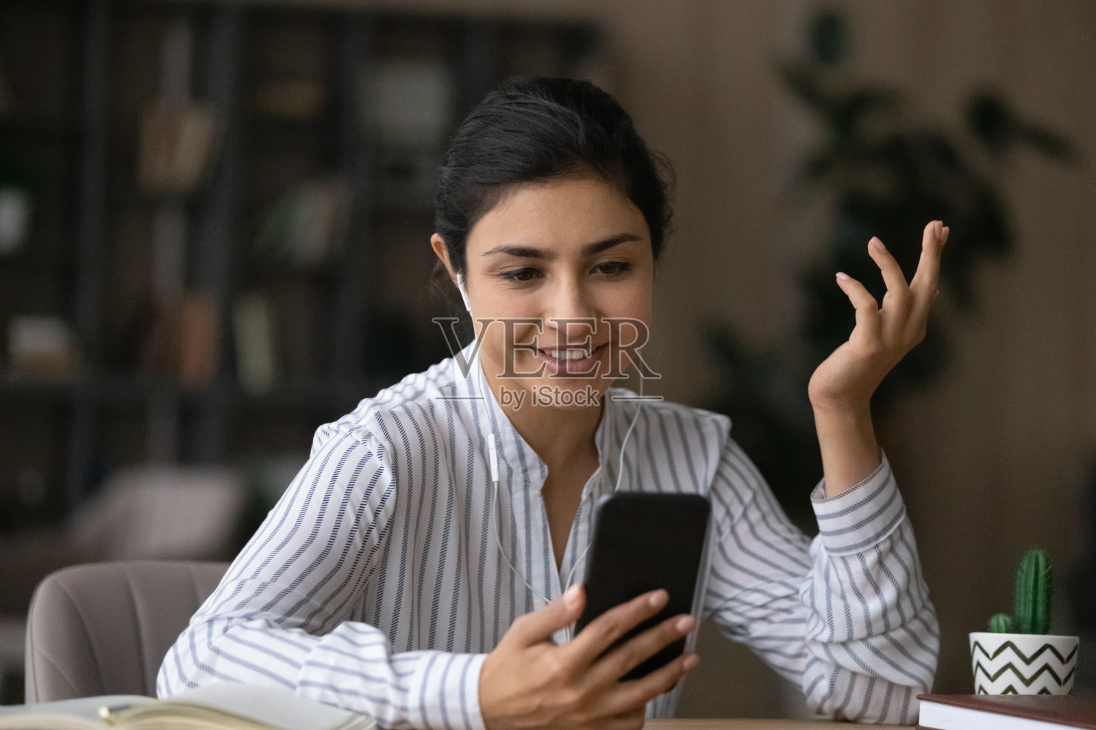 微笑的印度妇女在手机上用摄像头打电话照片摄影图片