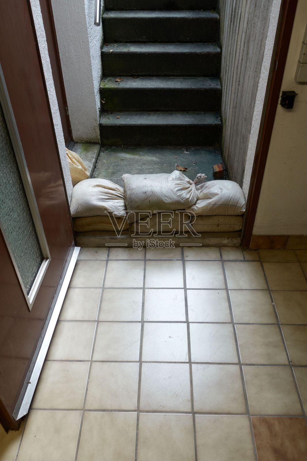 垂直拍摄的装满货物的袋子堆在一幢大楼的门口照片摄影图片