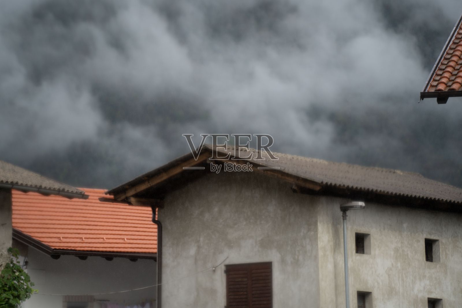 在斯洛文尼亚卡纳尔,阴云密布的天空下,老房子映衬着阴郁的一天照片摄影图片