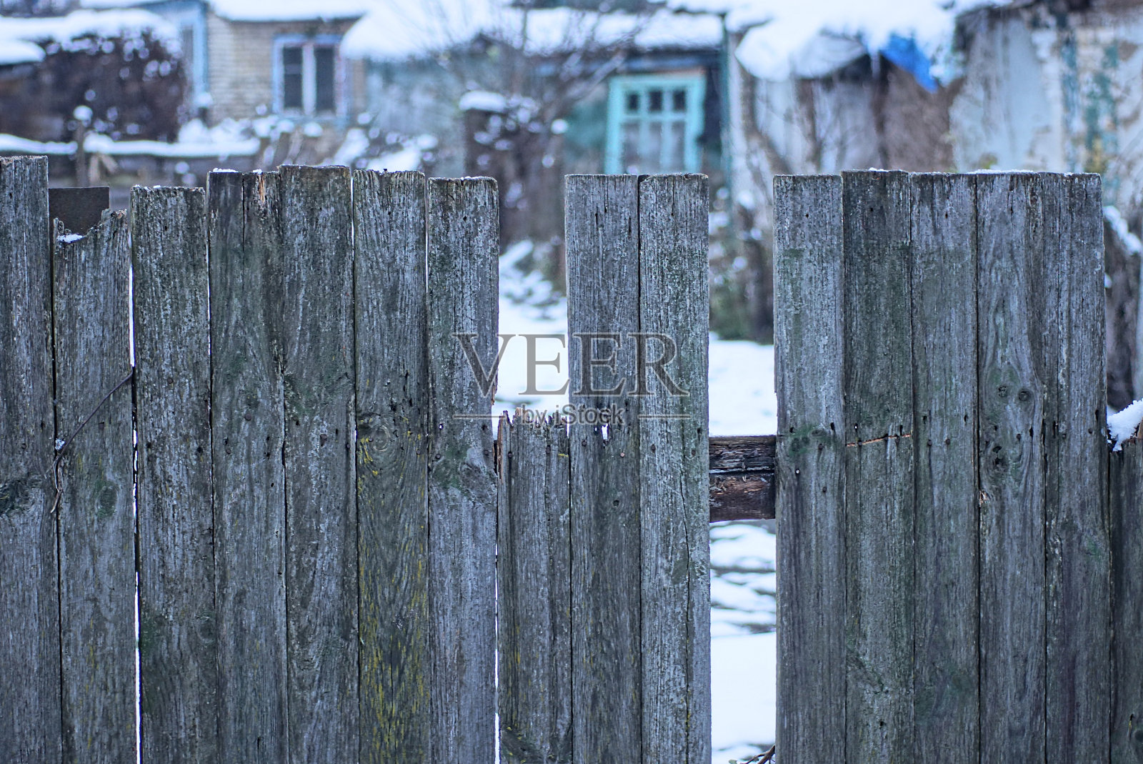旧的灰色栅栏墙的一部分,上面有破损的木板照片摄影图片