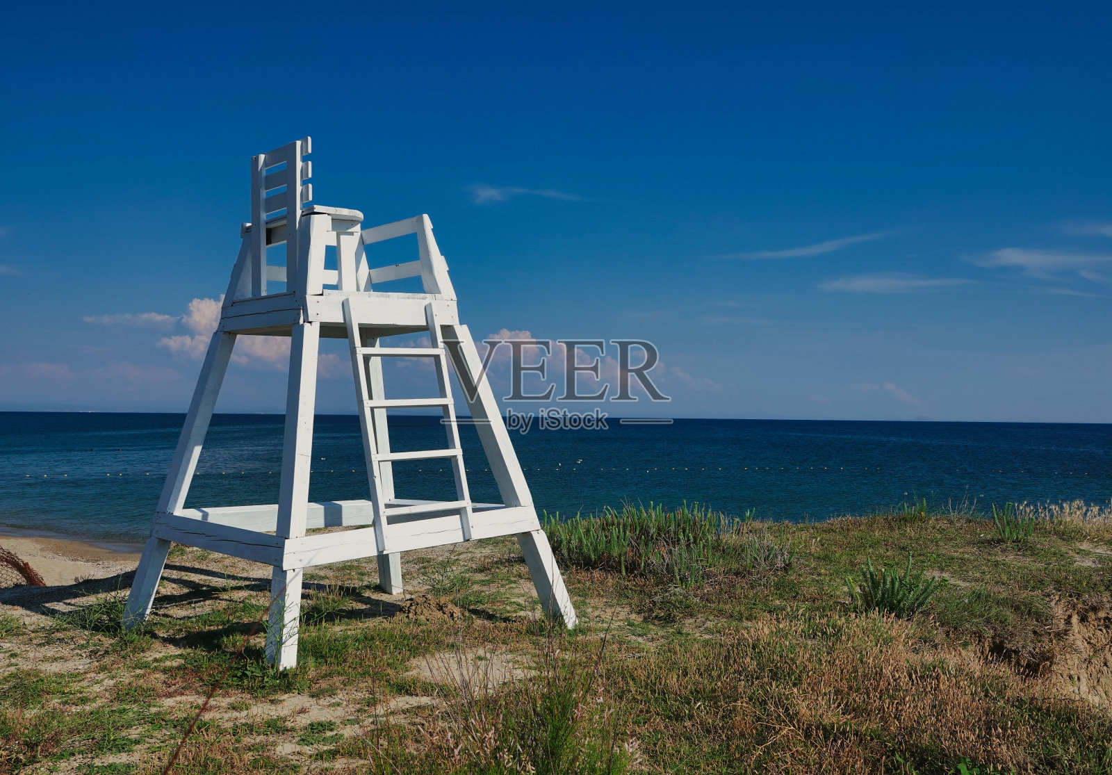 在Gokceada Kefalos海滩上,海鸥在空中飞翔,背景是一个古老的木制救生员凳,美丽的海滨照片摄影图片